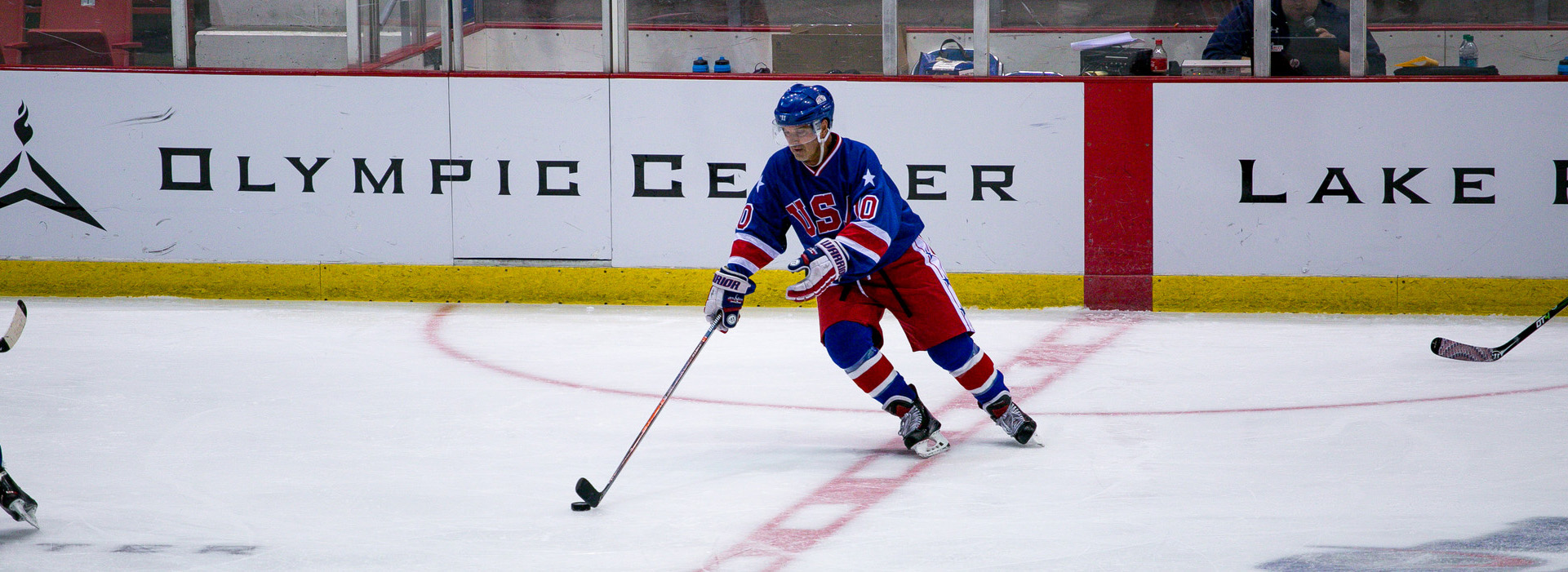 Hockey player and Miracle On Ice Fantasy Camper skating with the puck in the 1980 Herb Brooks Arena