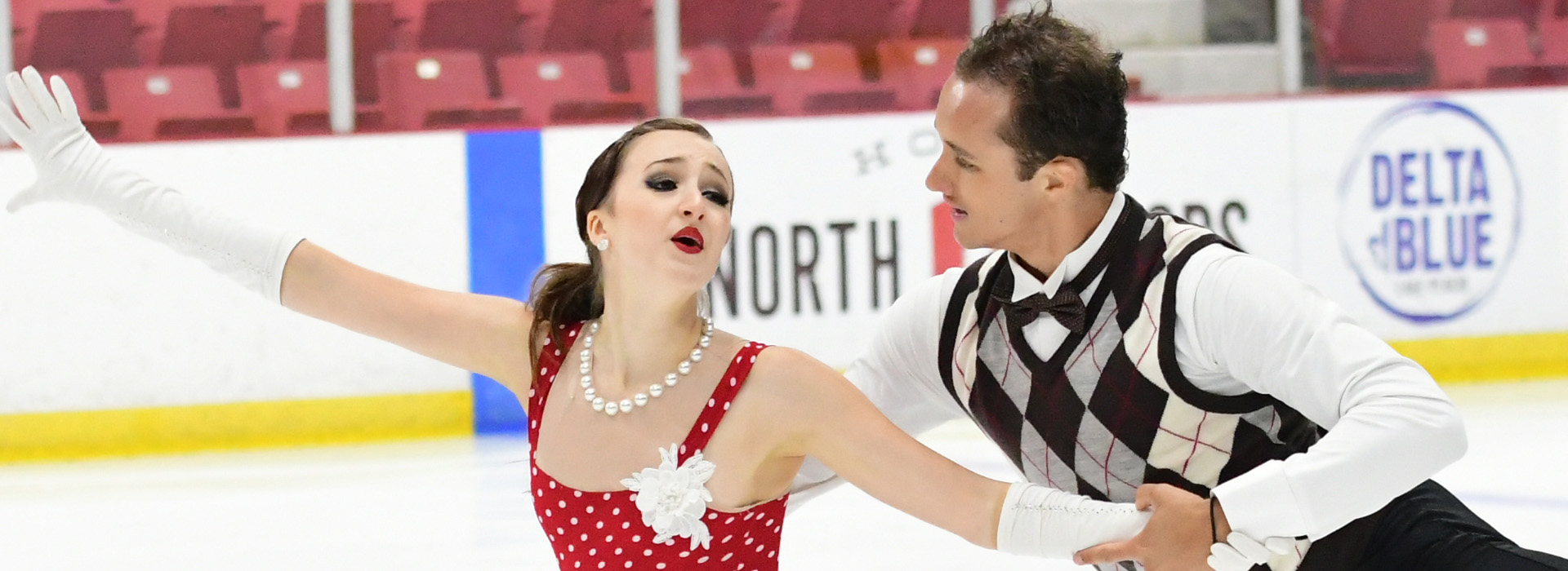Pairs skaters performing on ice at the Lake Placid Ice Dance Championship and International