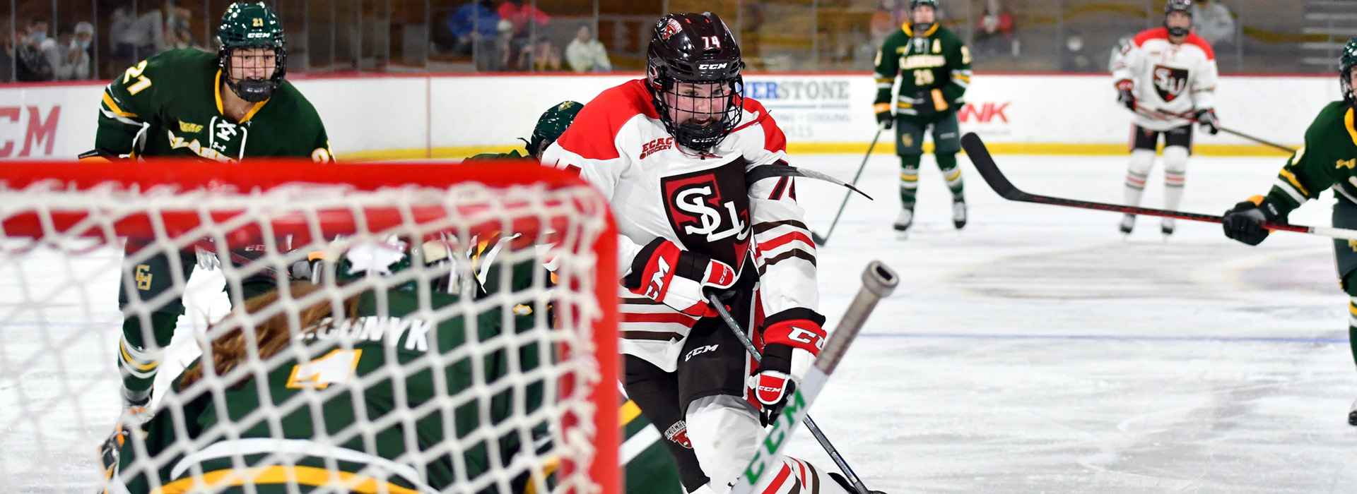 A St. Lawrence University women's ice hockey player breaks away and brings the puck close to the opposing net during competition.