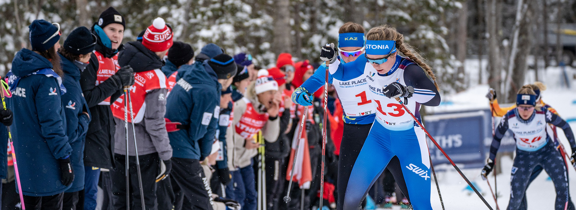 A crowd cheers on women cross country skiers in a race at Mt Van Hoevenberg.