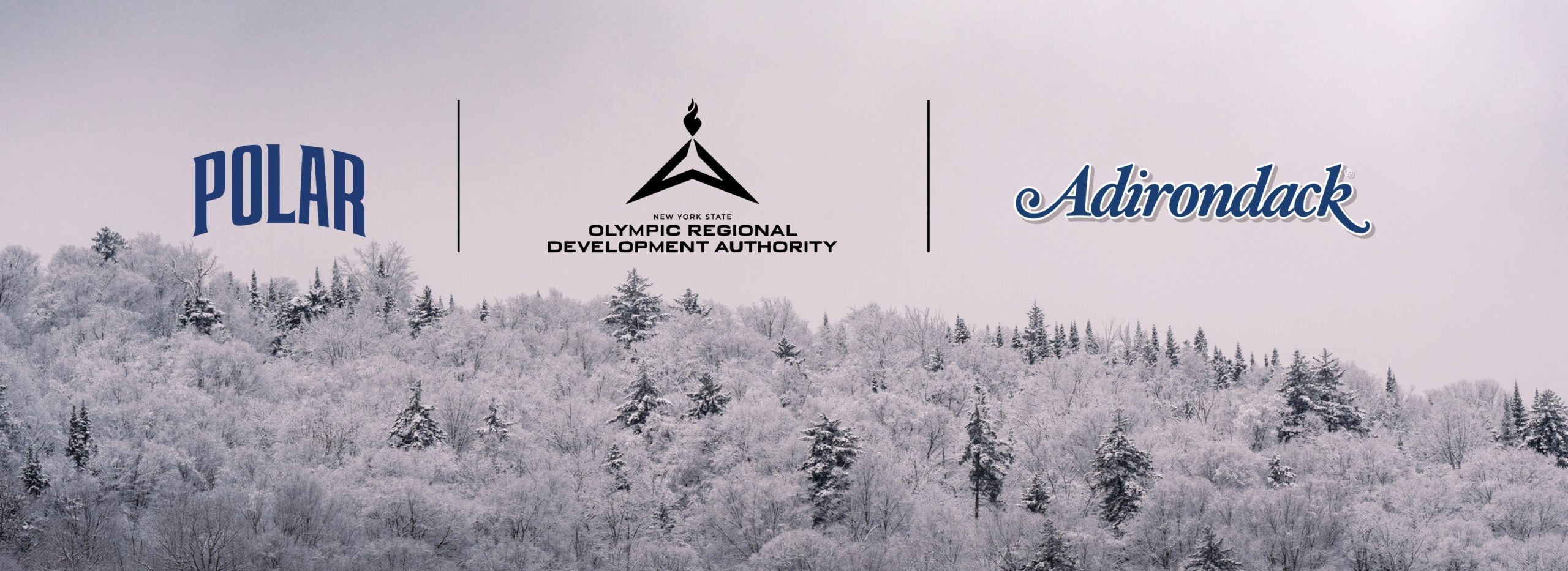 A tree-filled mountain side covered in snow and frost with three logos superimposed in the sky above. They are the Polar logo, the Olympic Authority logo, and the Adirondack Beverages logo.