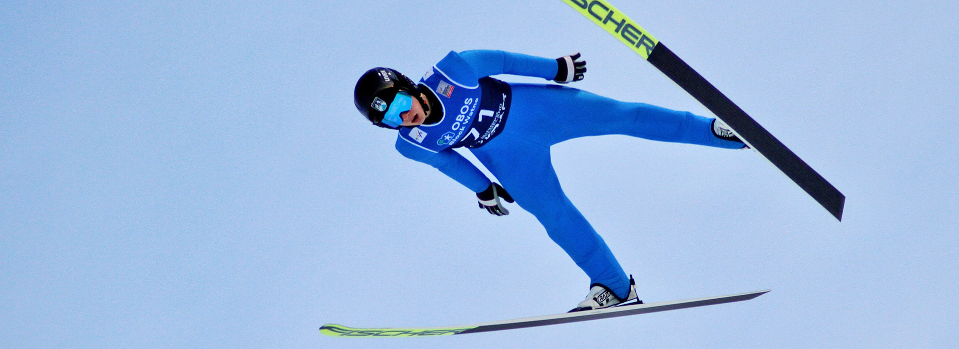 Tate Frantz soars through the air off a jump with nothing but blue sky around him.