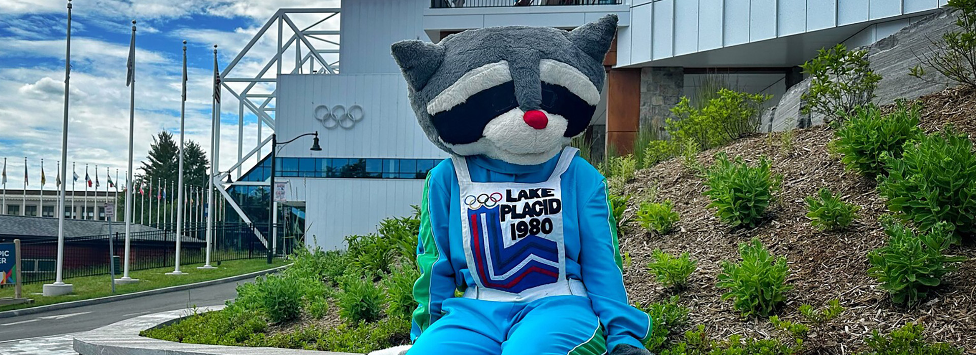 The 1980 Winter Olympic Games Mascot, Roni, sits outside the Olympic Center in Lake Placid on a summer day.