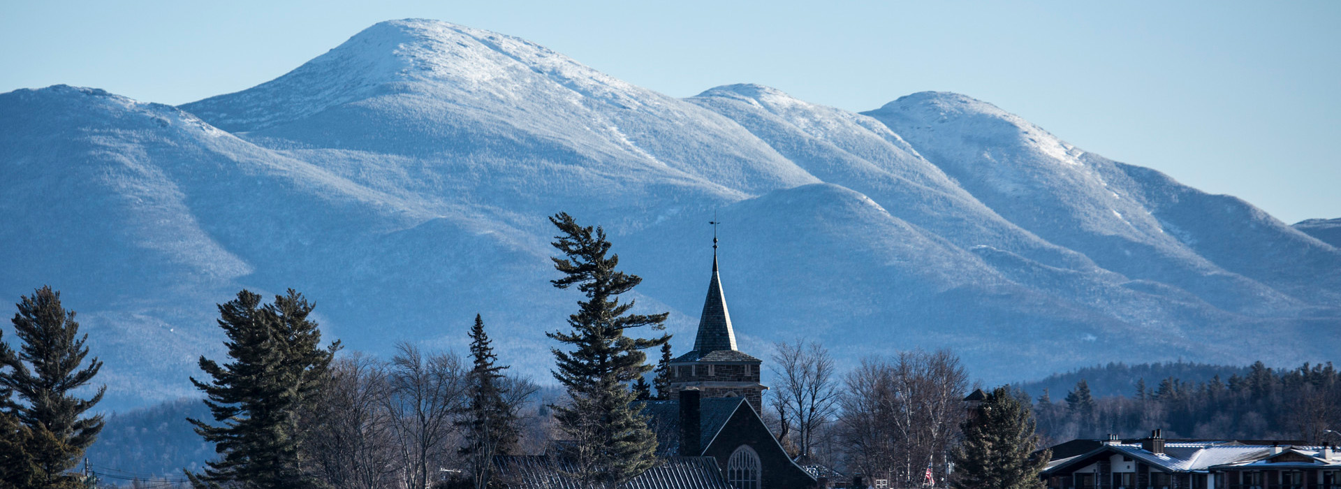 The Village of Lake Placid in the foreground with the Adirondack High Peaks in Winter in the background.