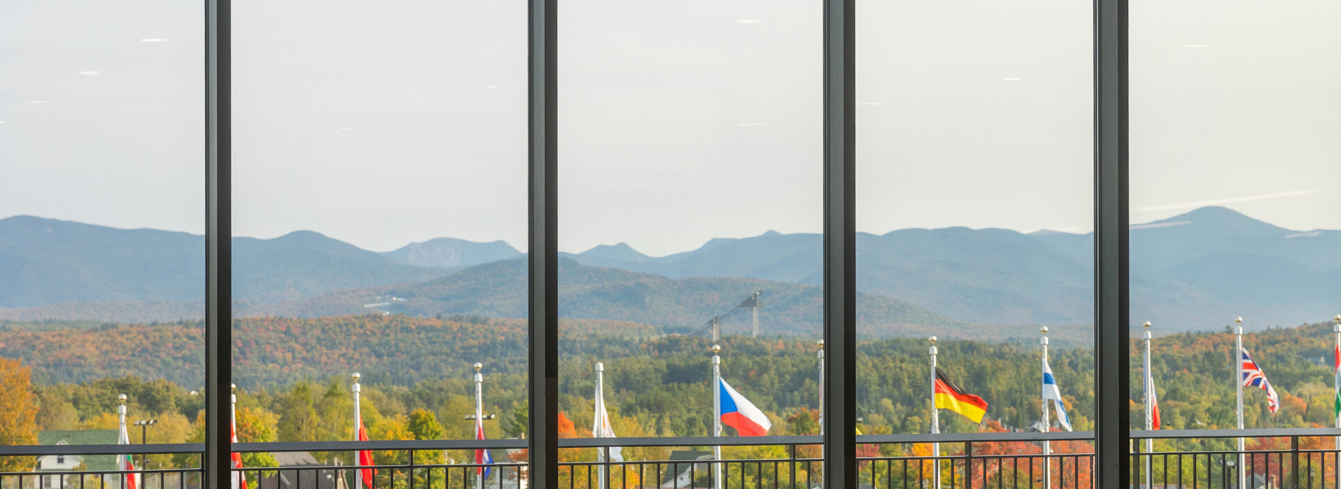 The view through the large, wide windows at Roamers' Cafe and Bar in the Olympic Center with the flags and mountains in the background.