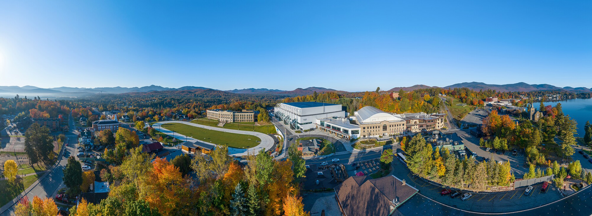 Aerial image of the Olympic Center in downtown Lake Placid in summer or early fall with a blue sky overhead.