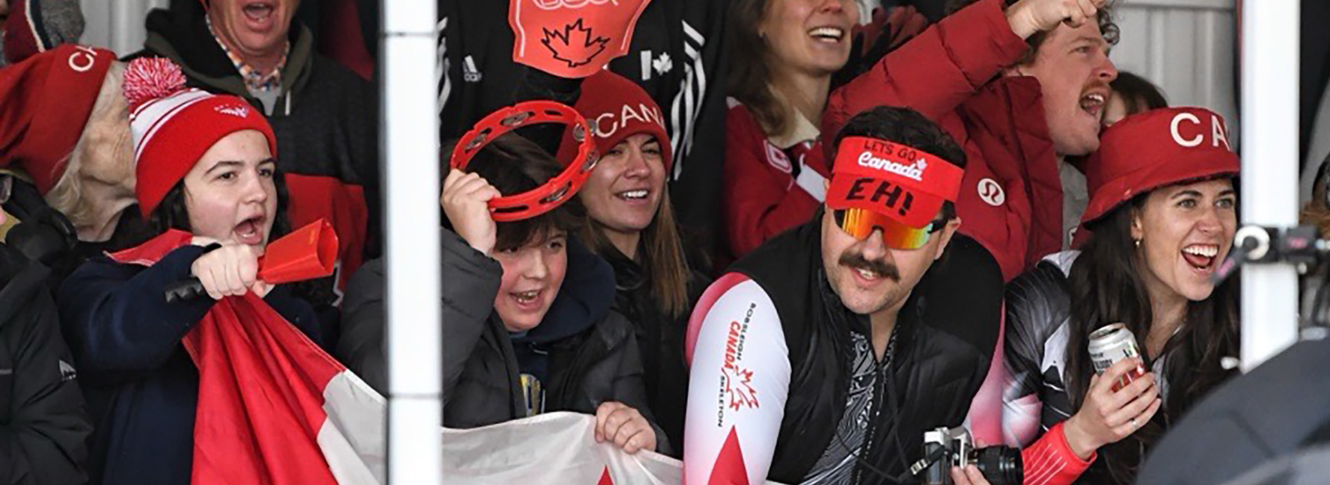 Canadian fans at the finish of the bobsled and skeleton World Championships smiling and cheering for their home team.