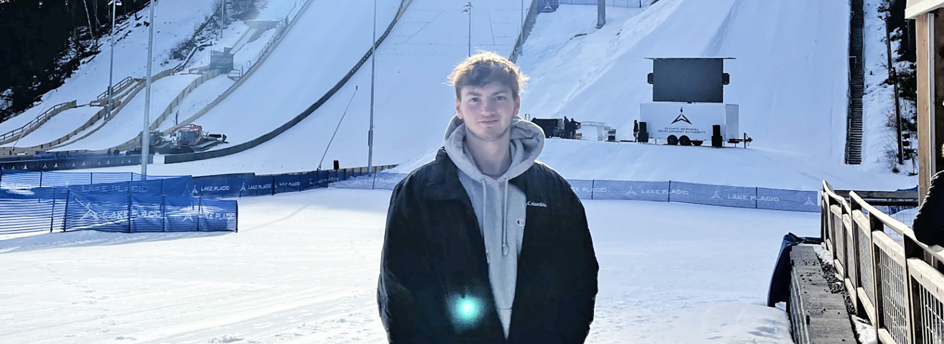 Portrait of Asa Mikelbank in winter wearing no hat standing on the outrun of the big ski jump hill.
