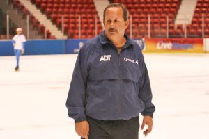Speed skating coach Tom Miller in a jacket standing on the ice inside the 1980 Herb Brooks Arena at the Olympic Center.