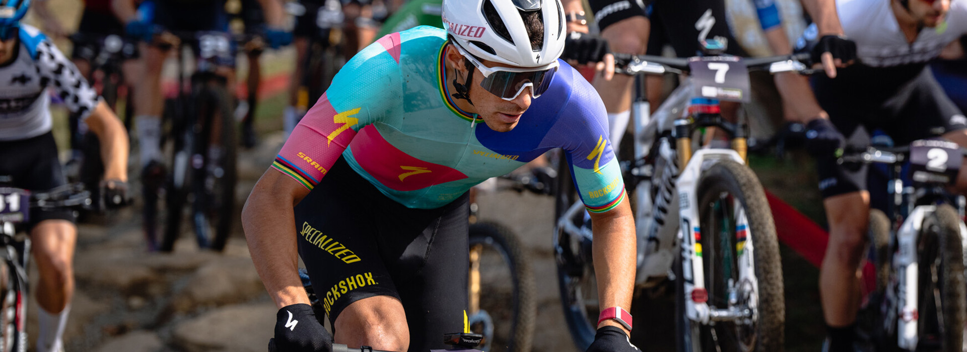 Christopher Blevins riding in a crowd of riders in the 2024 WHOOP UCI Mountain Bike World Series at Mt Van Hoevenberg.