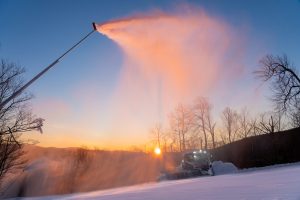 A Belleayre high-efficiency snow gun blowing powder as the sun sets behind it. 
