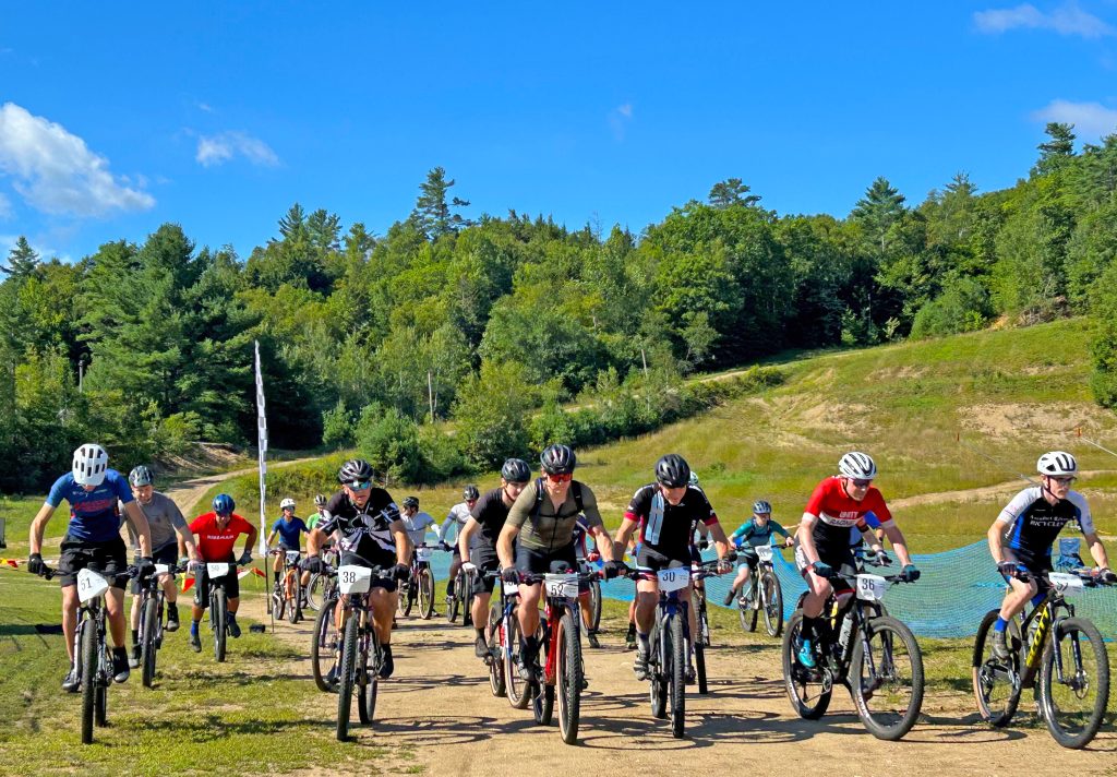 Riders line up for the start of the 4-6er race at the Ski Bowl with blue skies overhead.