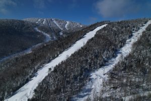 Trails on Gore Mountain in winter with one ski trail covered and smooth with the adjacent lift line rougher, demonstrating effective trail maintenance. 