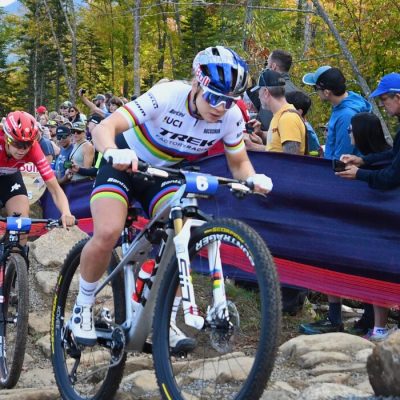 Female UKCI riders in a rock garden at Mt Van Hoevenberg with spectators looking on just a few feet away.