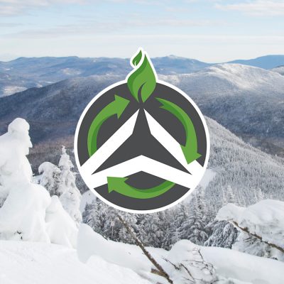 A spectacular winter scene from the top of Whiteface Mountain with the Olympic Authority sustainability symbol superimposed in the center.