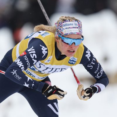 Jessie Diggins racing freestyle at Mt Van Hoevenberg in her yellow jersey, bent over and pushing hard.