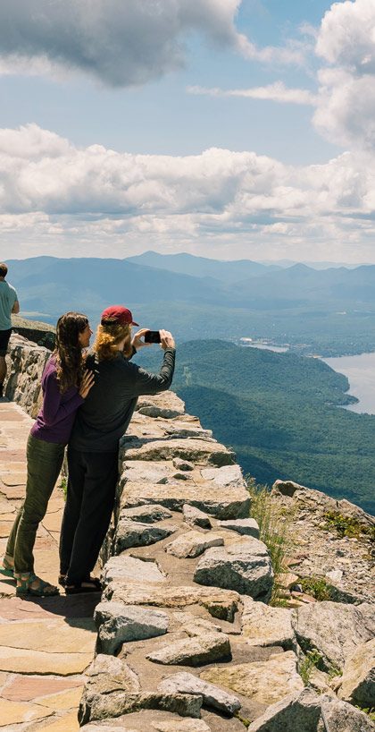 Sightseers taking a picture of Lake Placid from the top of the Whiteface Veterans' Memorial Highway.