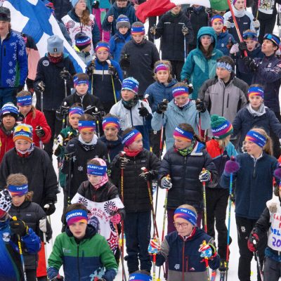 A crowd of youth cross-country skiers taken from above just after Jessie Diggins' last race as they all set out with her to ski a last loop around Mt Van Hoevenberg.