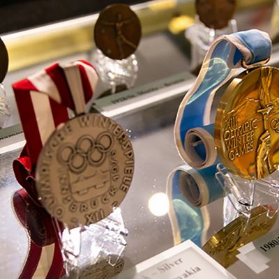 Medals from various Olympic Games, including at center frame, a Gold Medal from the 1980 Olympics in Lake Placid